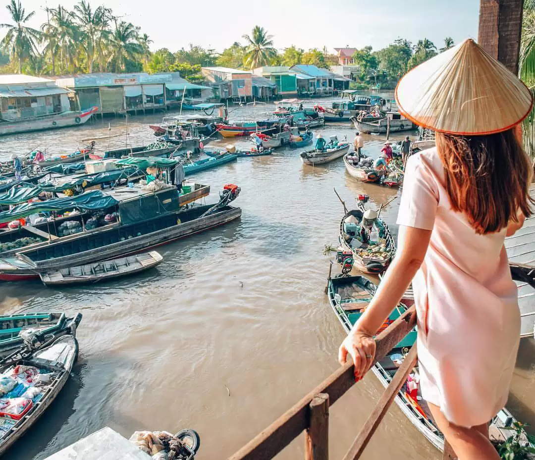 A female tourist taking photo in Cai Be floating market A female tourist taking photo in Cai Be floating market