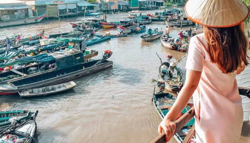 A female tourist taking photo in Cai Be floating market